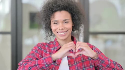 Woman with Curly Hair Makes Heart Shape