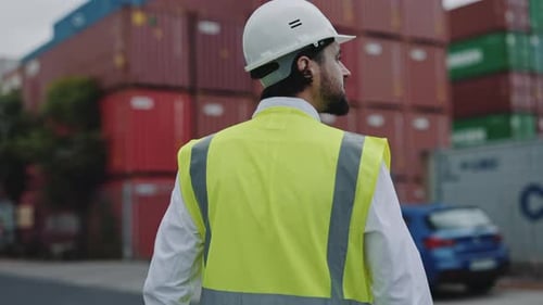 Back View of Man in Helmet Walking at Warehouse Harbor
