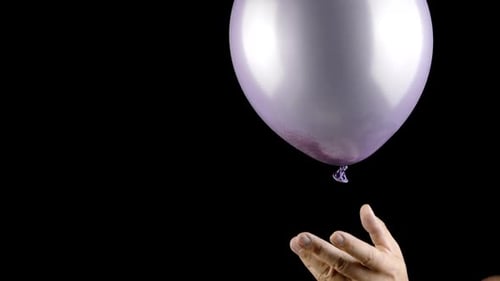 Purple Balloon Pops With Gold Glitter Against Black