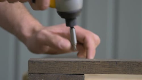 Hand using Power Drill to Insert Screw