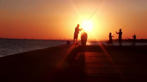 People Fishing on Pier During Brilliant Sunset