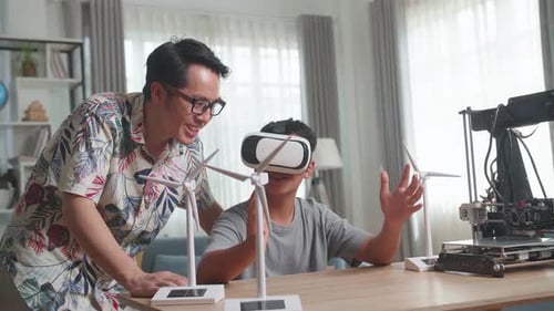 Asian Father Teach His Son While Wearing Vr Glasses With Electric Wind Turbine Model And 3D Printer