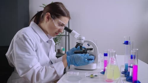 Woman Using Microscope in Lab Setting