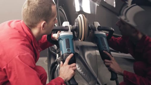 Professional Detailer Polishing Black Car