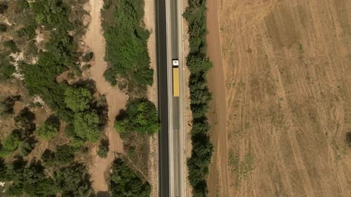 Truck loaded with Shipping Container driving on a rural highway, Aerial follow footage.