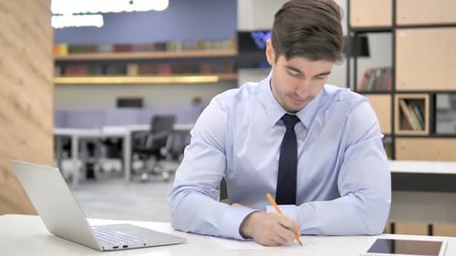 Young Adult Working in Office at Desk