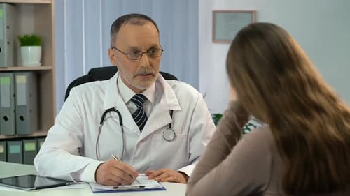 Doctor Consulting With Patient in Bright Office