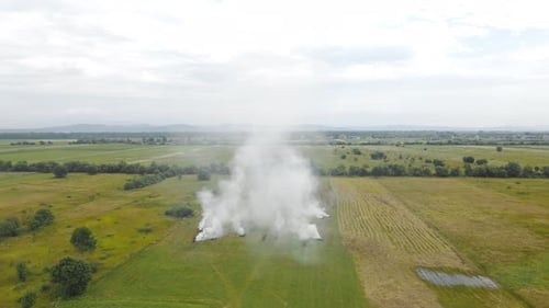 Aerial Flight People Burn Dry Grass in the Fields. Fire in the Field and Flying Over a Smoky Field