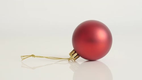 Tilting over Christmas ornament on white background close-up 4K 2160p 30fps UltraHD footage - Red