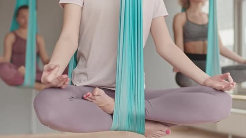 Young Women Doing Aerial Yoga in Studio