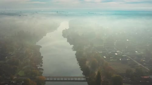 Beautiful morning, summer flight over the river, The bridge over the river in the fog, at dawn