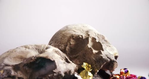 Skull and various candies against white background 4k