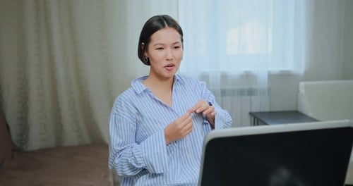Woman Smiling and Chatting on a Laptop