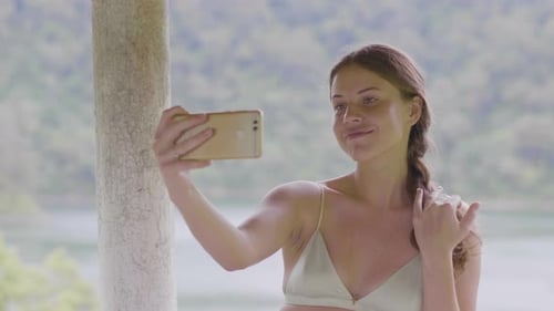 Seductive Woman Posing for Selfie Photo By Mobile Phone on Green Hill Covered Tropical Forest