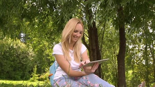 Happy Young Woman Using Tablet Computer in the Park, Slow Motion