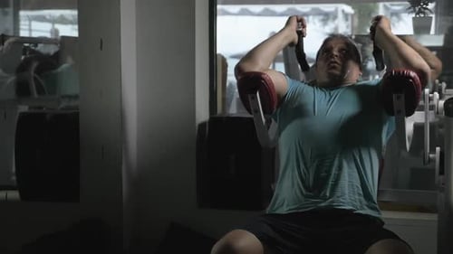 Mature man using situps machine in the gym
