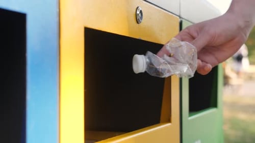 Recycling Bottle in a Yellow Trash Bin