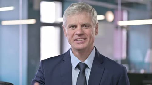 Confident Businessman Gives Thumbs Up in Modern Office