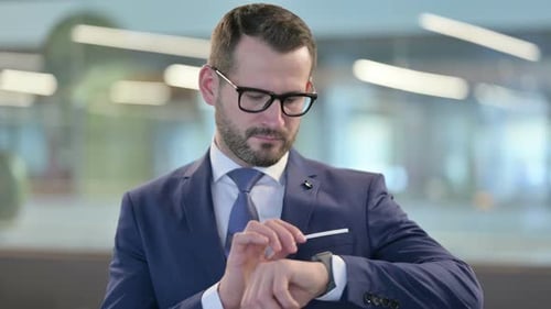 Portrait of Middle Aged Businessman Waiting and Checking Smartwatch