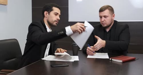 Men Reviewing Documents in Office Setting