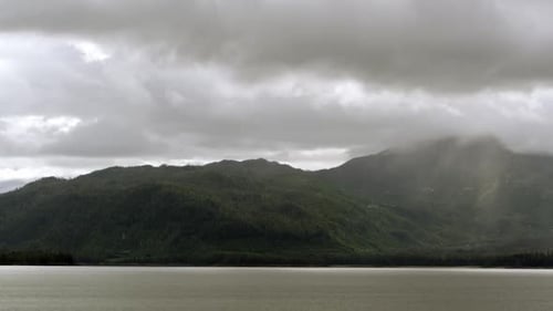 View from a cruise ship moving through the water parallel with a mountain