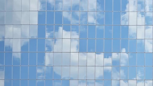 Cloudy blue sky reflection in building windows