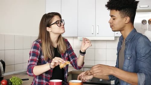 Couple Sharing Croissant in Bright Kitchen