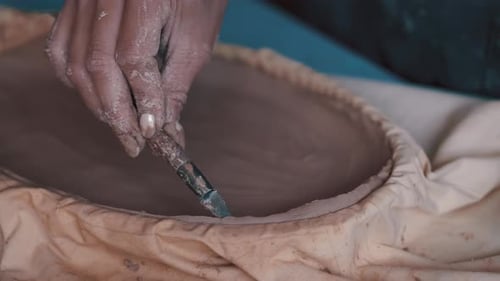 Hand Shaping Clay Dish With a Tool