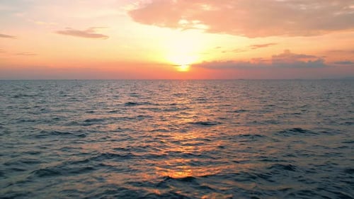 4K-Drohne fliegt über das Meer, Sonnenuntergang am Horizont.