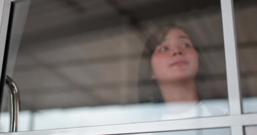 Smiling Woman Hanging Open Sign on Glass Door