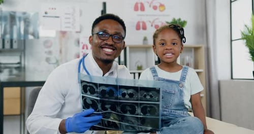 Doctor and Child with X-Ray in Hospital Office