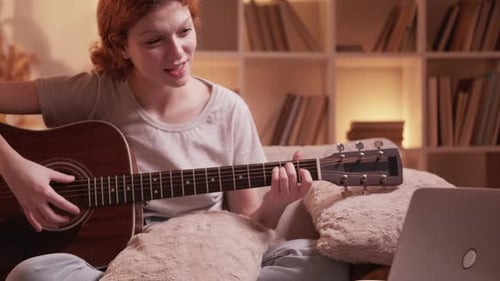 Woman Plays Acoustic Guitar at Home