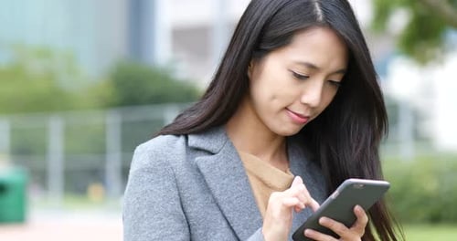 Woman Using Smartphone in Urban Park Setting