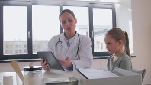 Doctor Showing Tablet Pc to Little Girl at Clinic