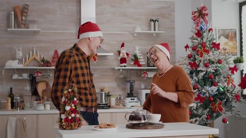 Senior Couple Exchanging Christmas Gifts in Cozy Kitchen