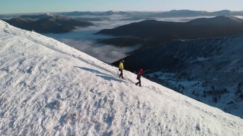 Drone Following Young Couple of Hikers on Mountain