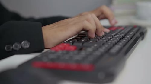 Close-up of hands typing on computer keyboard