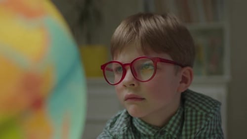 Close Up of Preschool Boy Studying Earth Globe