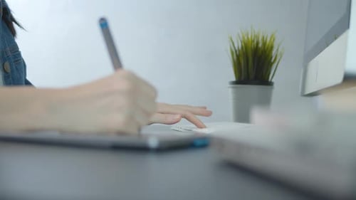Designer Using Stylus and Keyboard at Desk