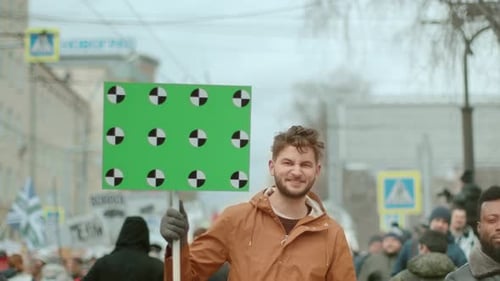 People Marching with Sign in an Urban Setting