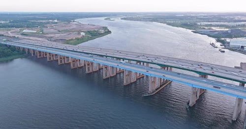 Luftaufnahme von unten auf Autos, die sich entlang der Brücke über den Fluss bewegen