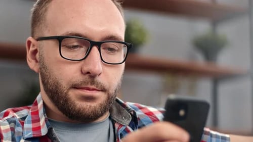 Man With Glasses Uses Smartphone