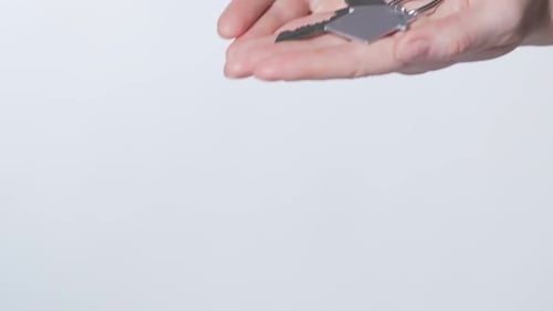 Weibliche Hände halten Schlüssel aus der Wohnung, Unterkunft zur Miete oder zum Verkauf anbieten