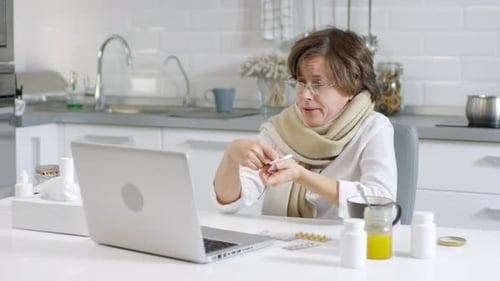 Woman with Cold Using Telemedicine in Kitchen
