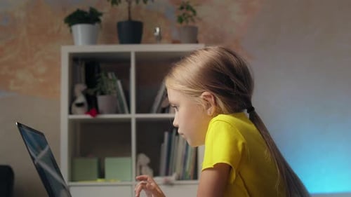 Young Girl Uses Laptop at Home