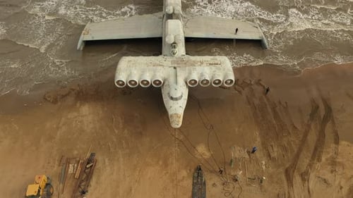 Large Airplane on Sandy Beach Next to Ocean