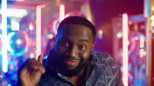 African American Guy Dancing Under Confetti. African Man Partying in Disco Club