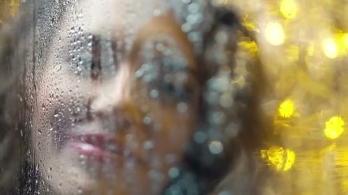 Woman Draws Heart on Rainy Window at Night