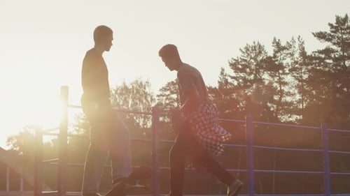 Two Young Adults at Skate Park at Sunset