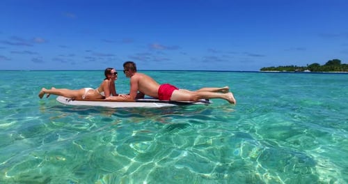 Happy lady and man on romantic honeymoon spend quality time on beach on paradise white sand